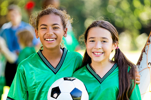 Happy diverse female soccer player after game